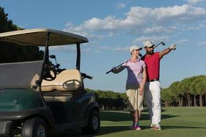 retrato de casal de golfistas no campo de golfe foto