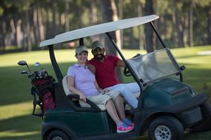 casal de buggy no campo de golfe foto