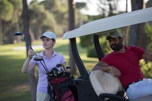 casal de buggy no campo de golfe foto