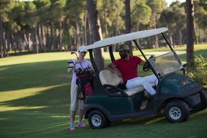 casal de buggy no campo de golfe foto