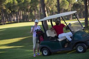 casal de buggy no campo de golfe foto