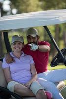 casal de buggy no campo de golfe foto