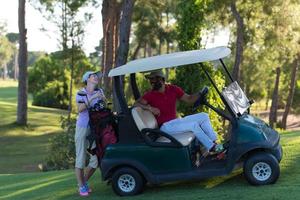 casal de buggy no campo de golfe foto