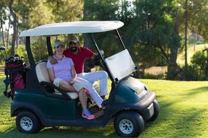 casal de buggy no campo de golfe foto