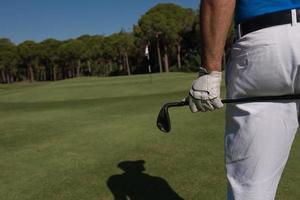 jogador de golfe fecha a mão e o motorista de trás foto