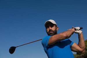 jogador de golfe acertando tiro foto