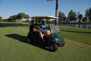 jogadores de golfe dirigindo carrinho no curso foto