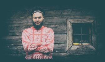 retrato de jovem hipster na frente da casa de madeira foto