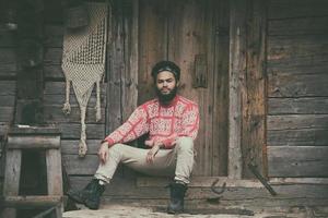 retrato de jovem hipster na frente da casa de madeira foto