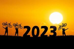 turistas aventureiros de bicicleta carregando bicicletas sobre obstáculos. feliz ano novo 2023 foto