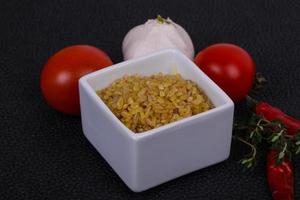 bulgur cru na tigela com tomate e alho foto