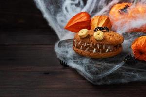 biscoitos com pasta de creme em forma de monstros para festa de halloween. carinhas caseiras engraçadas feitas de biscoitos de aveia e leite condensado fervido. espaço de cópia foto