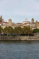 vista da cidade do porto na margem do rio ribeira e barcos de vinho rabelo no rio douro portugal uma cidade património mundial da unesco. foto