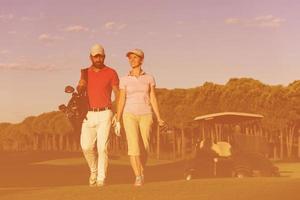 casal andando no campo de golfe foto