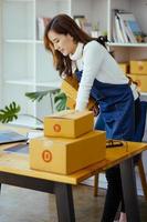 trabalho a partir de casa. mulheres felizes vendendo produtos on-line startup proprietários de pequenas empresas estão pegando caixas de encomendas para embalar pedidos de clientes e prepará-los para postagem. foto