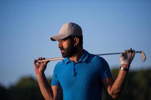 retrato de jogador de golfe no campo de golfe no pôr do sol foto