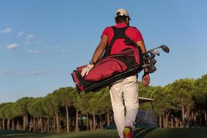 golfista andando e carregando bolsa de golfe foto