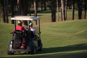 casal de buggy no campo de golfe foto