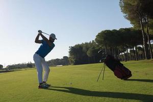 jogador de golfe acertando tiro foto