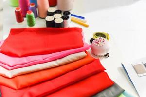 ferramentas artesanato linha de costura e linha de agulha para designer de moda em estúdio material têxtil tesoura corte tecido roupas máquina de costura designer trabalhando profissional pano de tecido colorido