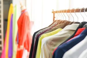 roupas de moda feminina de roupas de cores diferentes em cabides no showroom - roupas penduradas terno colorido ou rack de armário foto