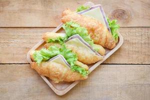 sanduíches de croissant na mesa de madeira, vista superior - vegetais de presunto de salada de croissant foto