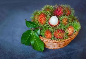 rambutan fresco e maduro doce de frutas tropicais descascadas rambutan com folha na cesta, colheita de frutas rambutan da árvore de rambutan do jardim foto