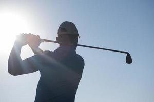 jogador de golfe acertando tiro foto