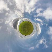 pequeno planeta no céu azul com belas nuvens. transformação do panorama esférico 360 graus. vista aérea abstrata esférica. curvatura do espaço. foto