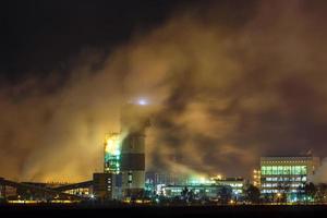 noite paisagem industrial poluição ambiental resíduos de usina termelétrica. grandes tubos da planta da empresa da indústria química foto