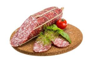 salame na placa de madeira e fundo branco foto