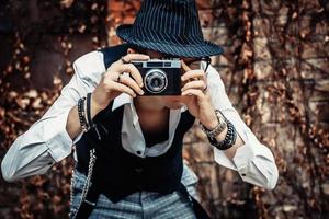 fotógrafo de estilo retrô tirando foto com câmera fotográfica analógica.