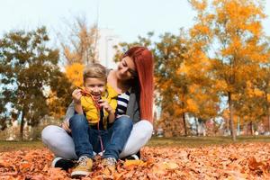 feliz mãe e filho durante o dia de outono no parque. foto