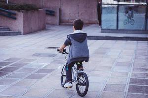 vista traseira do menino andando de bicicleta. foto