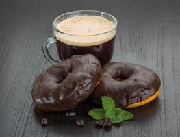 café com donuts em fundo de madeira foto