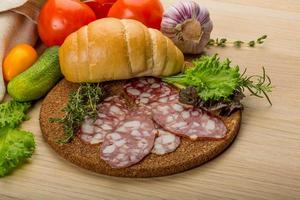 salame na placa de madeira foto