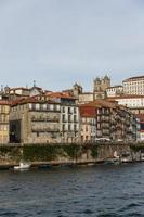 vista da cidade do porto na margem do rio ribeira e barcos de vinho rabelo no rio douro portugal uma cidade património mundial da unesco. foto