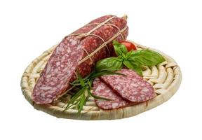 salame na placa de madeira e fundo branco foto