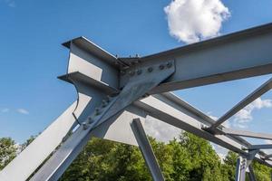 construção de armação de aço de ferro da ponte sobre fundo de céu azul. estruturas metálicas de pontes, armações, parafusos e porcas foto