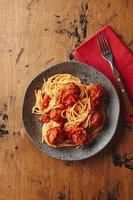 macarrão espaguete com almôndegas e molho de tomate. deliciosas almôndegas de espaguete caseiro foto