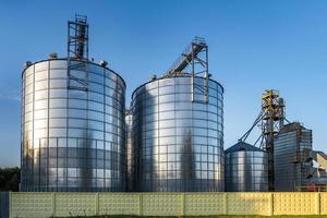 moderno elevador de celeiros com silos de prata em agro-processamento e planta de fabricação para processamento de secagem, limpeza e armazenamento de produtos agrícolas, farinhas, cereais e grãos. foto