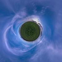 transformação verde minúsculo planeta do panorama esférico 360 graus. vista aérea abstrata esférica em campo com céu azul escuro à noite. curvatura do espaço. foto