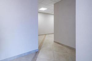 longo corredor vazio branco no interior do hall de entrada de apartamentos modernos, escritório ou clínica foto