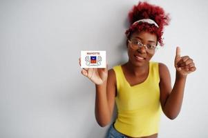 mulher africana com cabelo afro, use camiseta amarela e óculos, segure a bandeira de maionese isolada no fundo branco, mostre o polegar para cima. foto