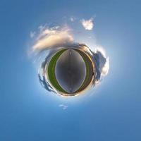 pequeno planeta no céu azul com sol e belas nuvens. transformação do panorama esférico 360 graus. vista aérea abstrata esférica. curvatura do espaço. foto