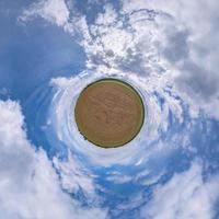 pequeno planeta verde no céu azul com belas nuvens. transformação do panorama esférico 360 graus. vista aérea abstrata esférica. curvatura do espaço. foto