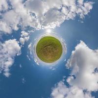 pequeno planeta verde no céu azul com belas nuvens. transformação do panorama esférico 360 graus. vista aérea abstrata esférica. curvatura do espaço. foto