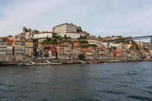 vista da cidade do porto na margem do rio ribeira e barcos de vinho rabelo no rio douro portugal uma cidade património mundial da unesco. foto