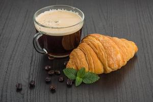 café com croissant em fundo de madeira foto