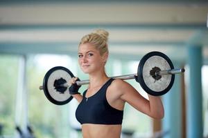 jovem no ginásio de fitness levantando pesos foto